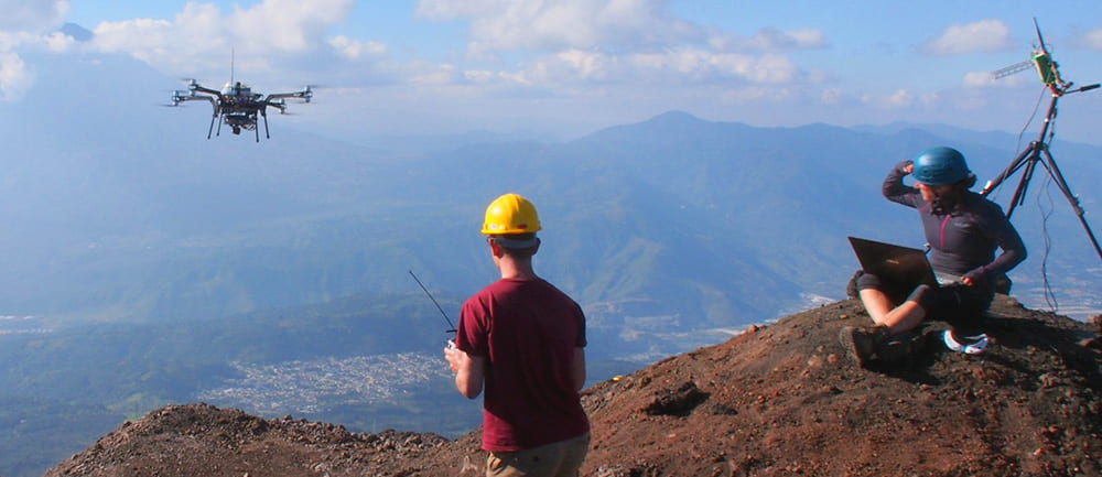 Researchers flying drone from side of a volcano