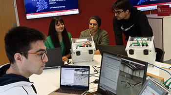 Four cyber security students in a lab